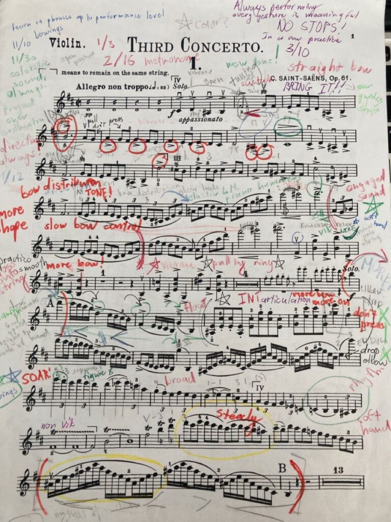 Heavily marked violin concerto sheet music showing intense practice notes and perfection-driven reminders